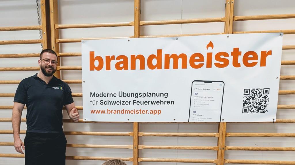 Samuel Bader neben dem brandmeister-Banner am Jugendfeuerwehr-WBK 2026 in Wittenbach
